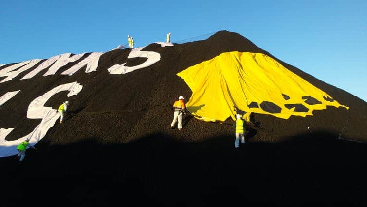 Greenpeace members protesting at Newcastle port in 2017, calling on the Commonwealth Bank to stop investing in coal. (Jaz Kaelin/The Conversation)