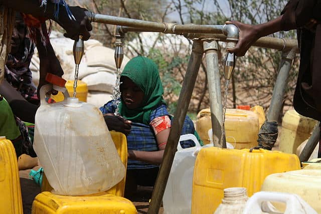 Newly arrived refugees collect water at an Oxfam tap stand in Africa. Photo: Anna Ridout/Oxfam