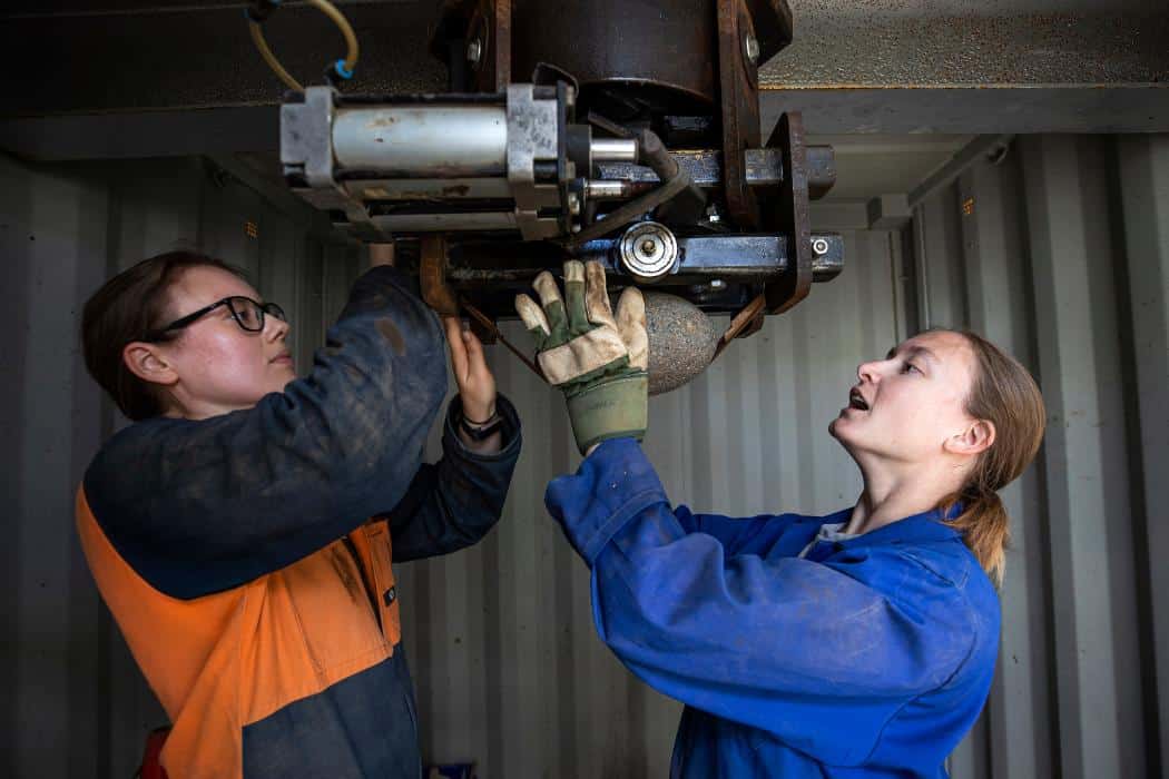 Nicole Allen (left) and Amilea Sork attach a volcanic rock to ‘the cannon’, an air-pressure based launching mechanism at the University of Canterbury to replicate the effect of volcanic ballistics during an eruption. Photo: EQC
