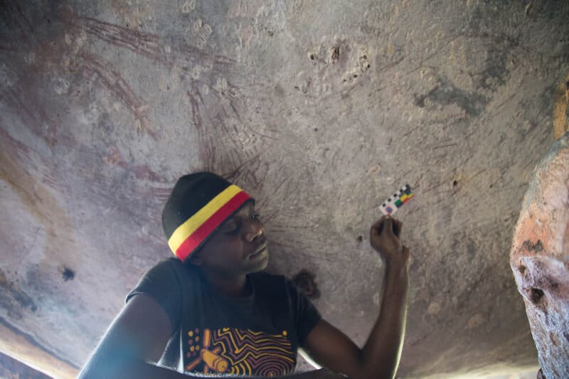 Traditional owner, Ian Waina, recording the estimated 17,300 year old painting of a kangaroo found in a hard-to-access rock cluster in the northeast Kimberley region. Image: Peter Veth, Balanggarra Aboriginal Corporation