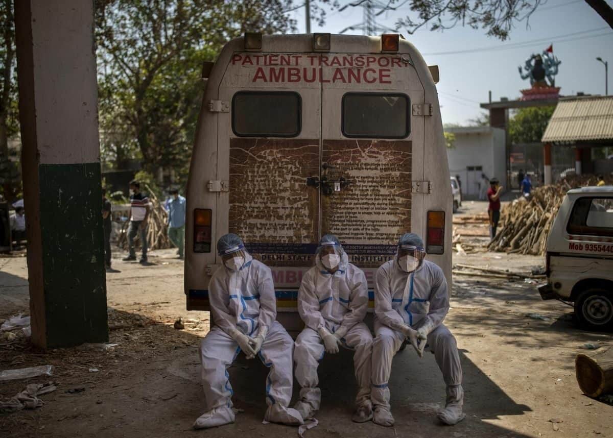 Exhausted crematorium workers sit on an ambulance in New Delhi, India, Saturday, April 24 2021. Photo: AP Photo/Altaf Qadri.
