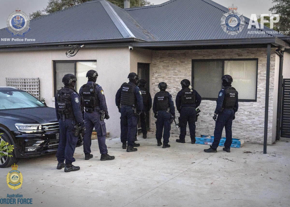 Officers prepare to search one of the properties last week. Photo credit: AFP